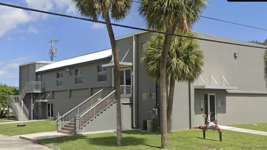 Gray cannabis office building with palm trees.